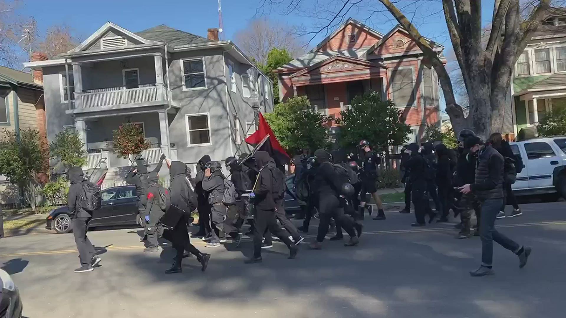 A group of demonstrators leaves Neely Park in Sacramento and heads down G Street. Their affiliation is unclear.