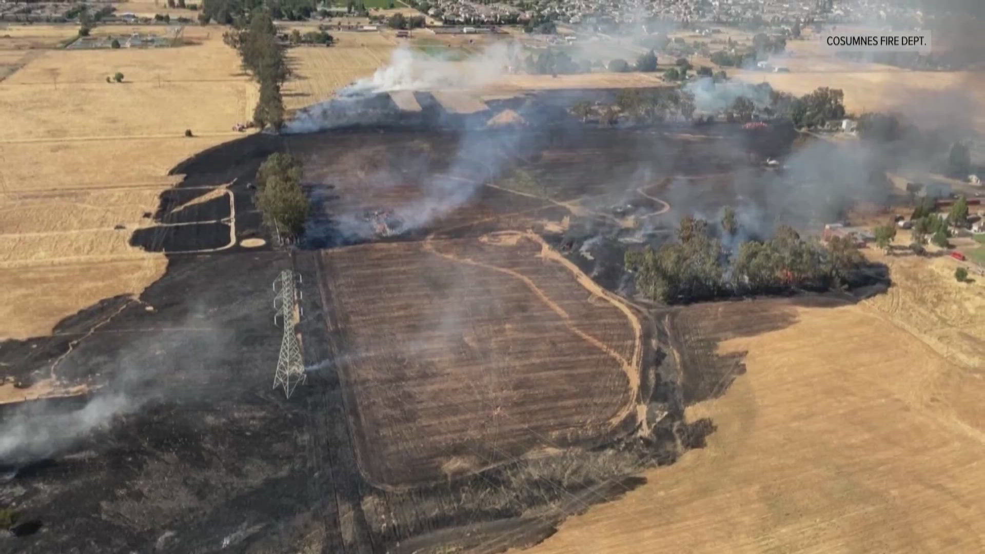 A grass fire burning in Elk Grove threatened multiple structures and damaged some outbuildings.  