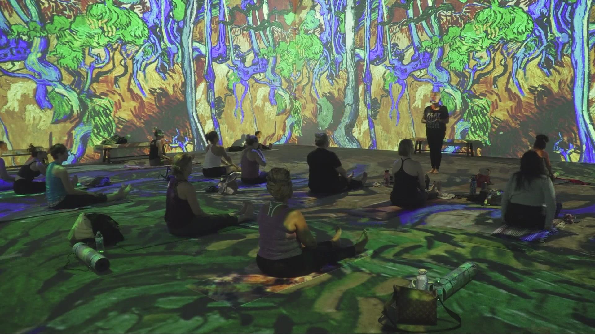 A beginners yoga class is held in a room with interactive, moving van Gogh art. Those who participate can relax, stretch and view colorful art pieces all at once.