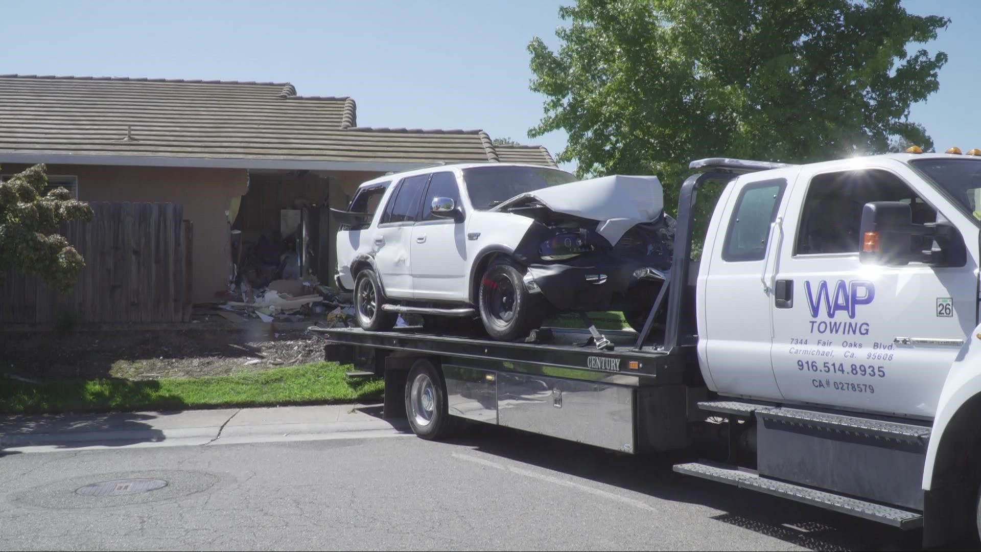 A photo from the Sacramento Metropolitan Fire District shows a white vehicle with damage to the front end inside a home.