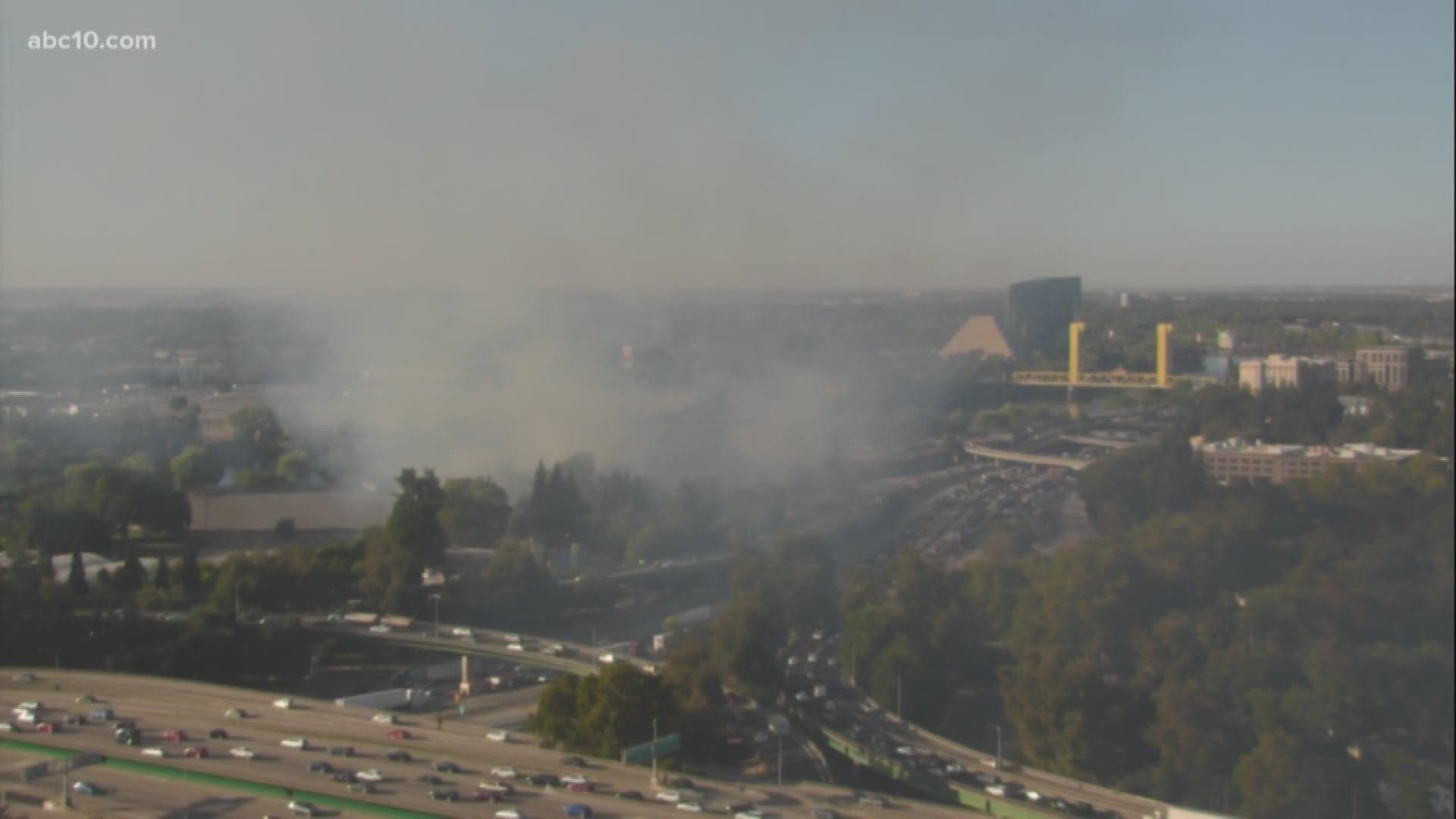 A large grass fire is causing a significant amount of smoke and traffic issues in the downtown Sacramento area Monday evening, according to the California Highway Patrol.