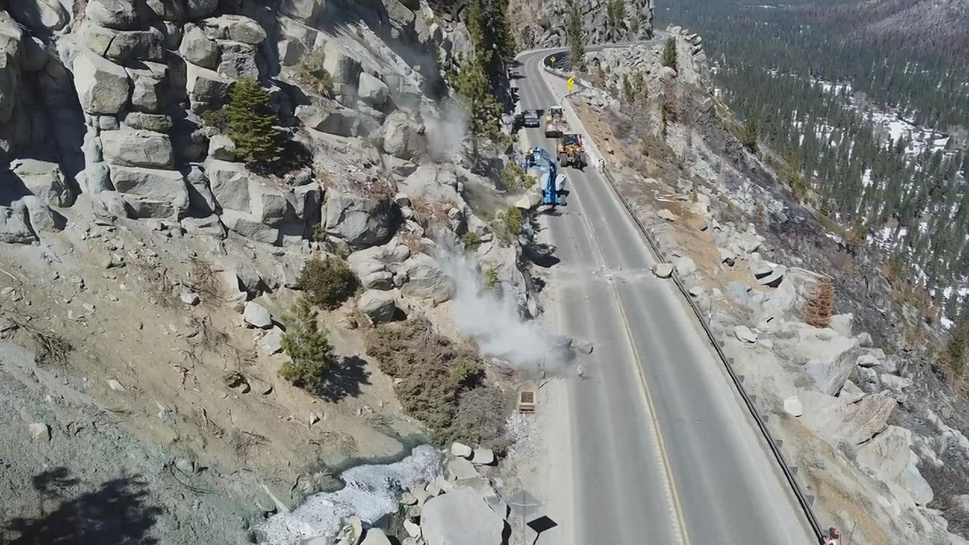 Crews are reportedly using hand tools and airbag devices to break down the large boulders―sending them tumbling down the slope. Video by Kelly Wisner at Caltrans.