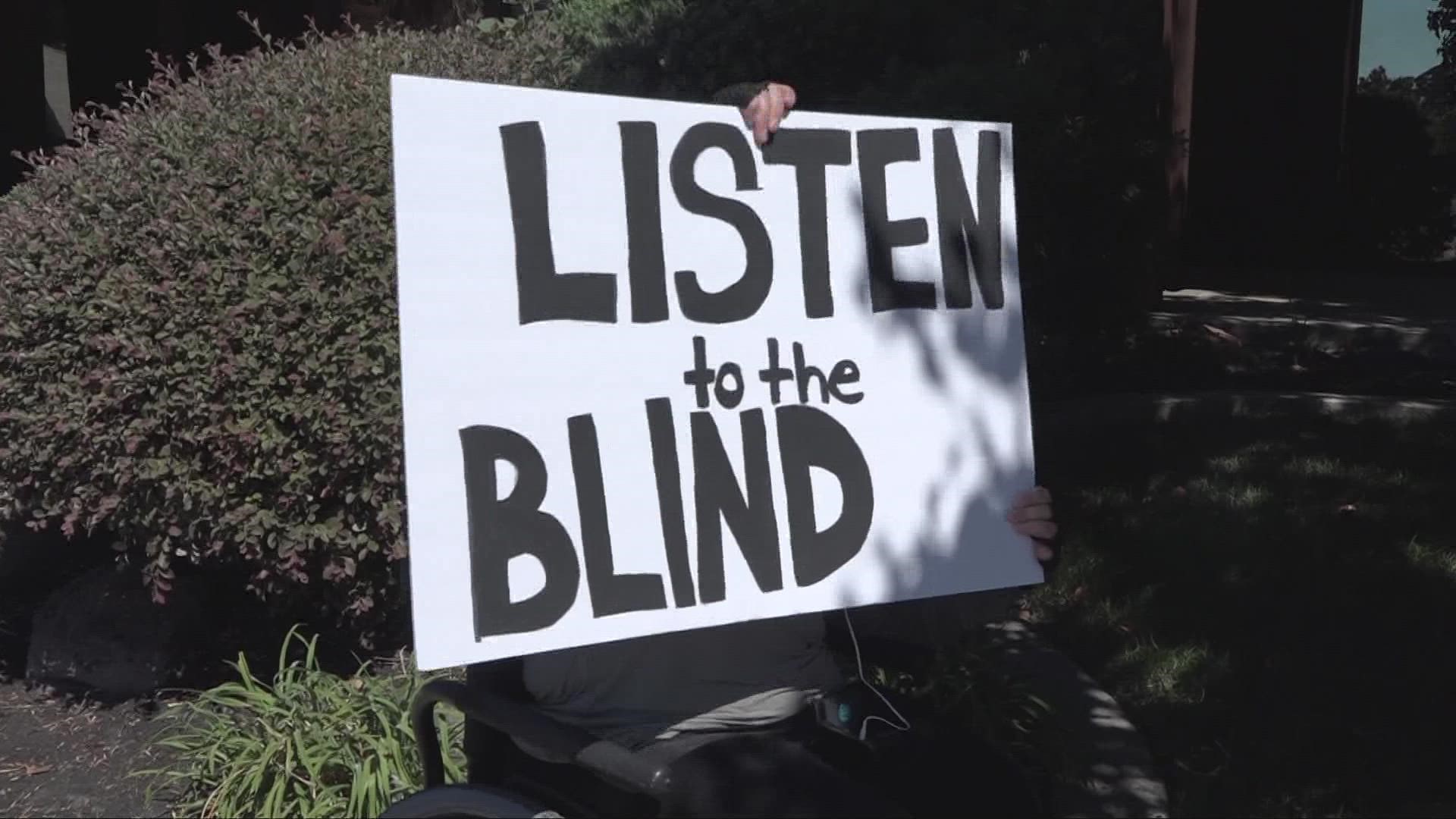 Carrying signs reading "Listen to the Blind" and "Defund CCBVI," a small group of advocates for the blind protested on the sidewalk in North Stockton.